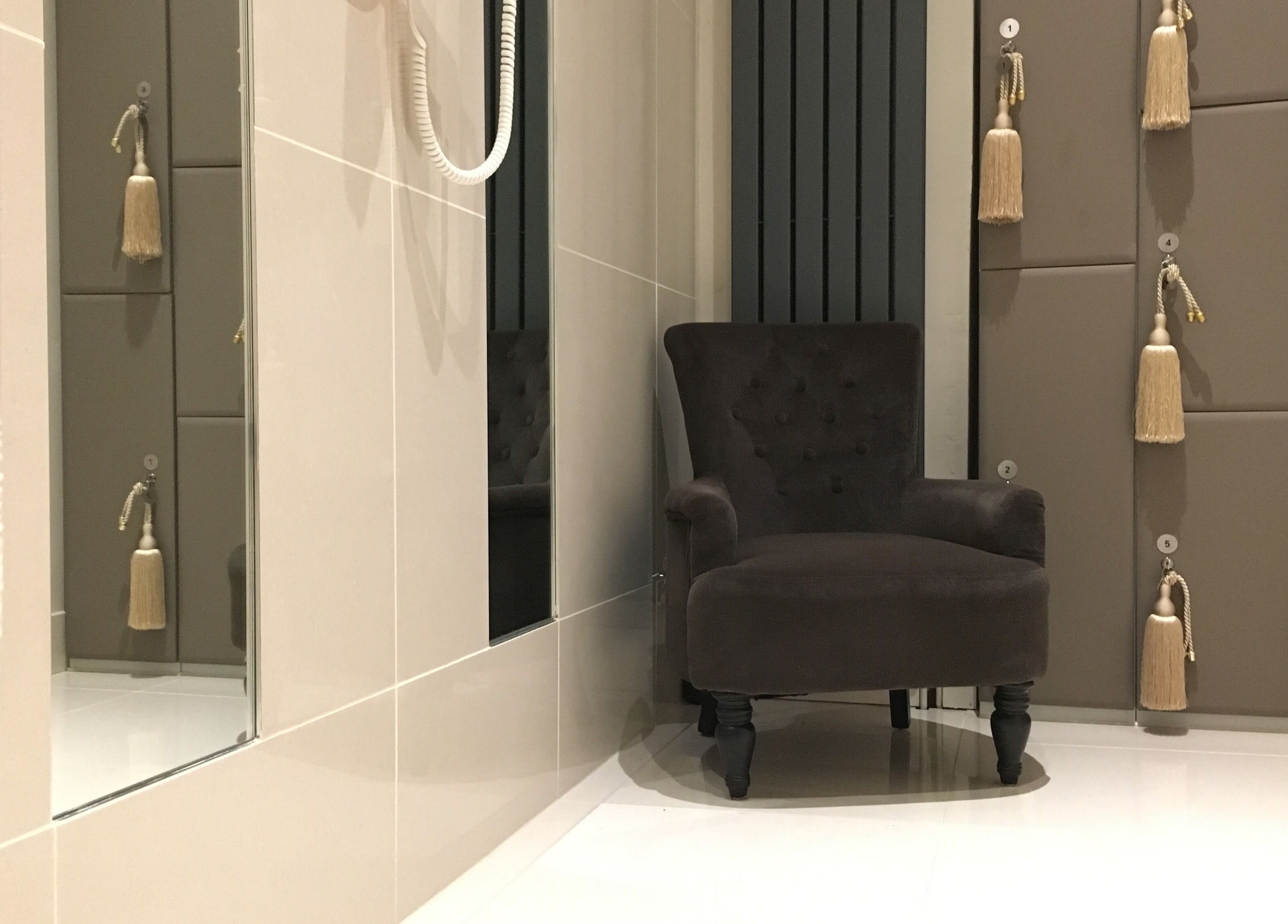 Relaxing nook with plush chair at Thy Spa Oxford, Oxford, England, GB, featuring tassel-accented lockers.