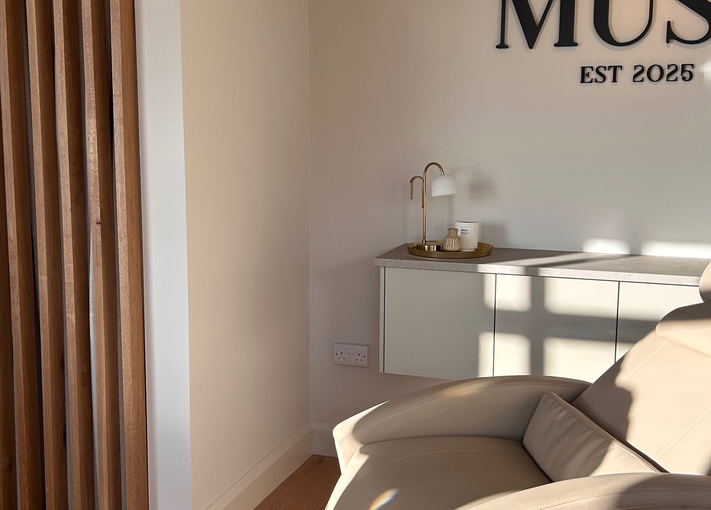 Modern lounge chair at Muse - Ballyclare, Northern Ireland, GB, featuring chic decor and ambient lighting.