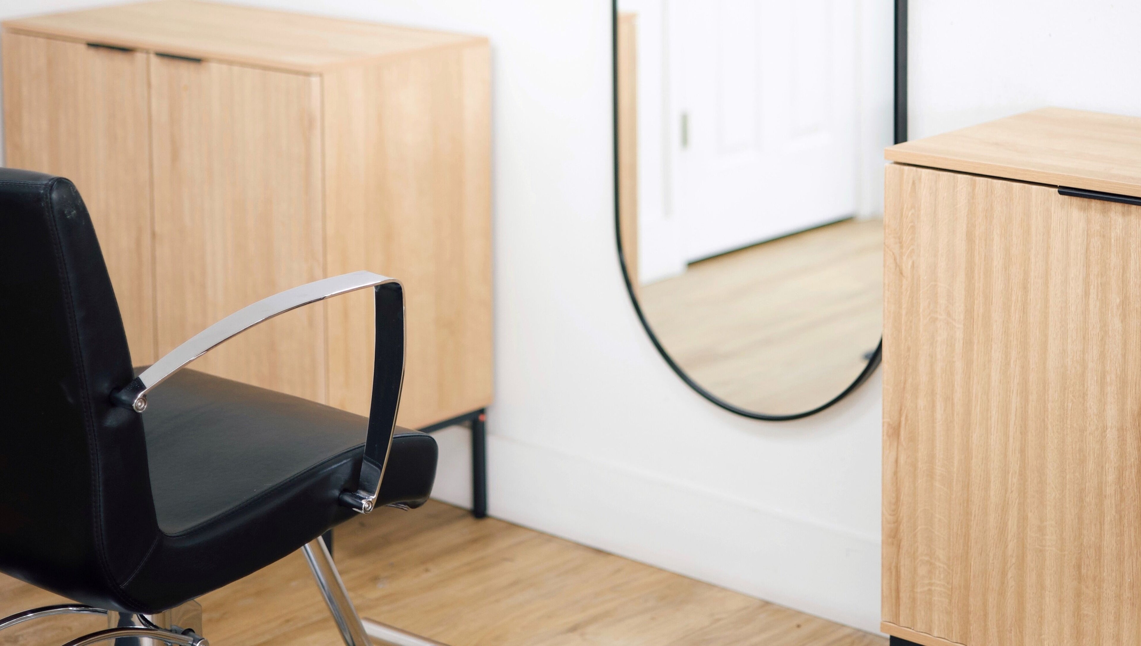 Modern salon chair and mirror at Sand + Sol Studio in Rogers, Arkansas, US highlighting style and elegance.