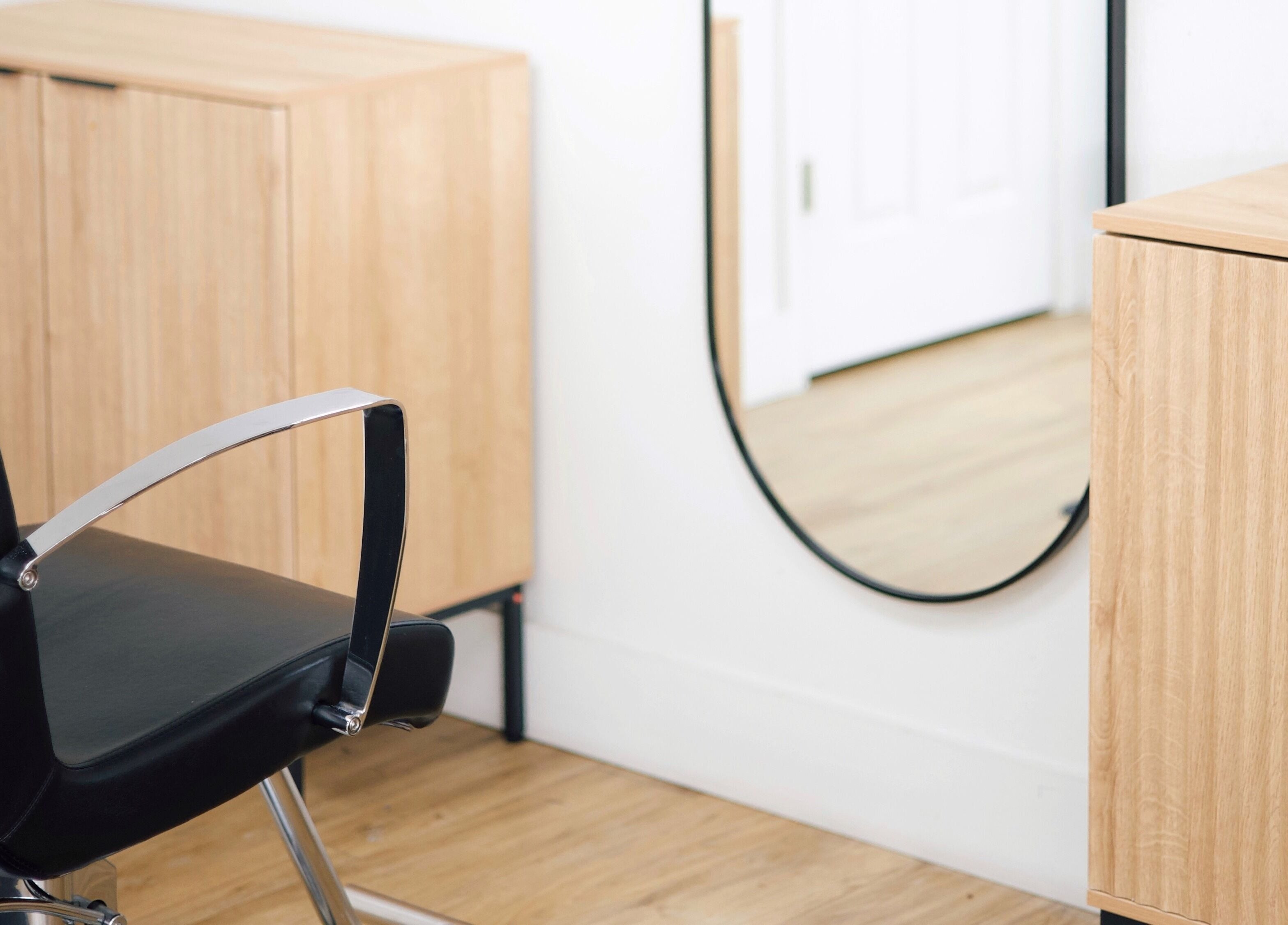 Modern salon chair and mirror at Sand + Sol Studio in Rogers, Arkansas, US highlighting style and elegance.