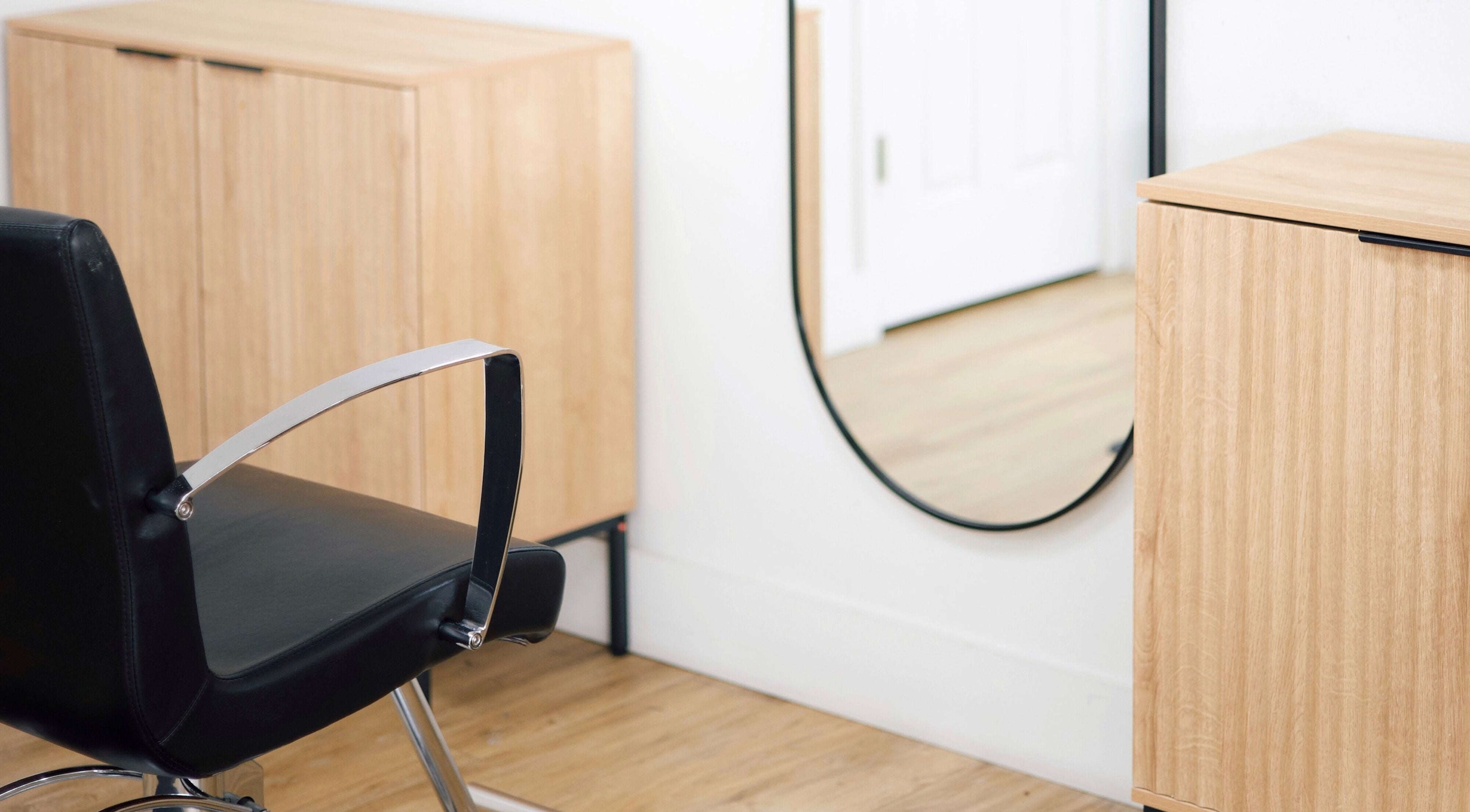 Modern salon chair and mirror at Sand + Sol Studio in Rogers, Arkansas, US highlighting style and elegance.