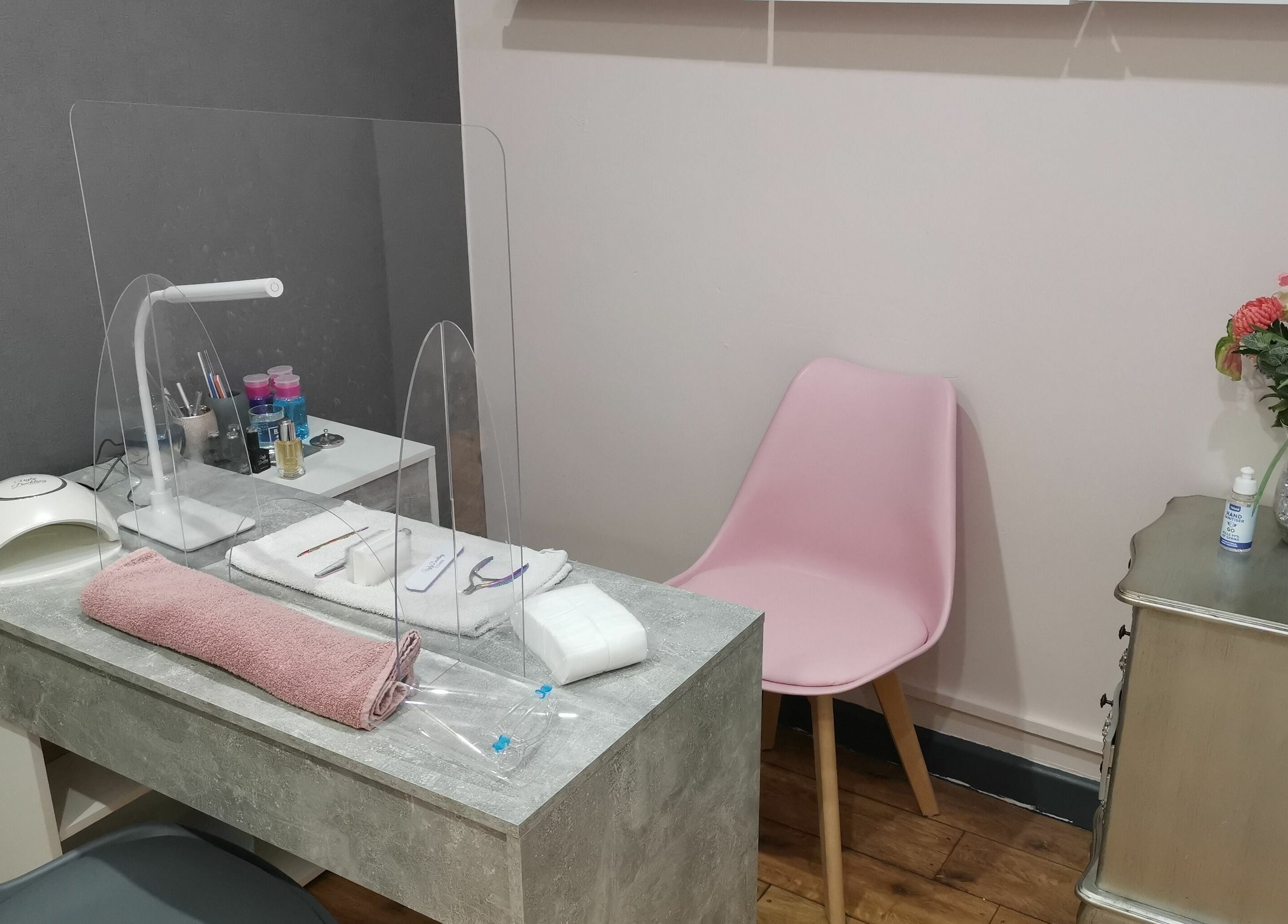 Elegant nail station at Lucy Jorge, Langport, England, GB with pink chair and flowers, showcasing a serene space.