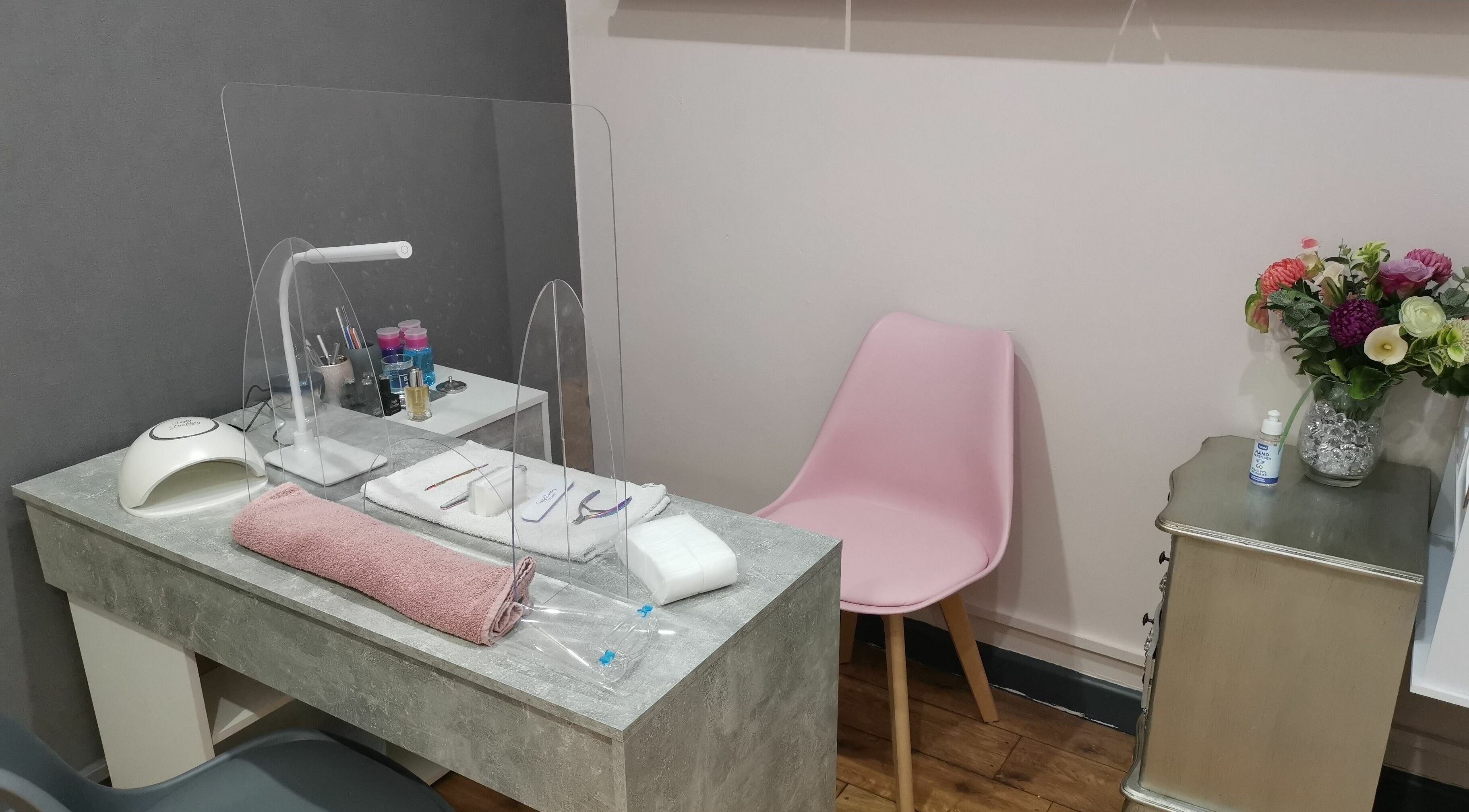 Elegant nail station at Lucy Jorge, Langport, England, GB with pink chair and flowers, showcasing a serene space.
