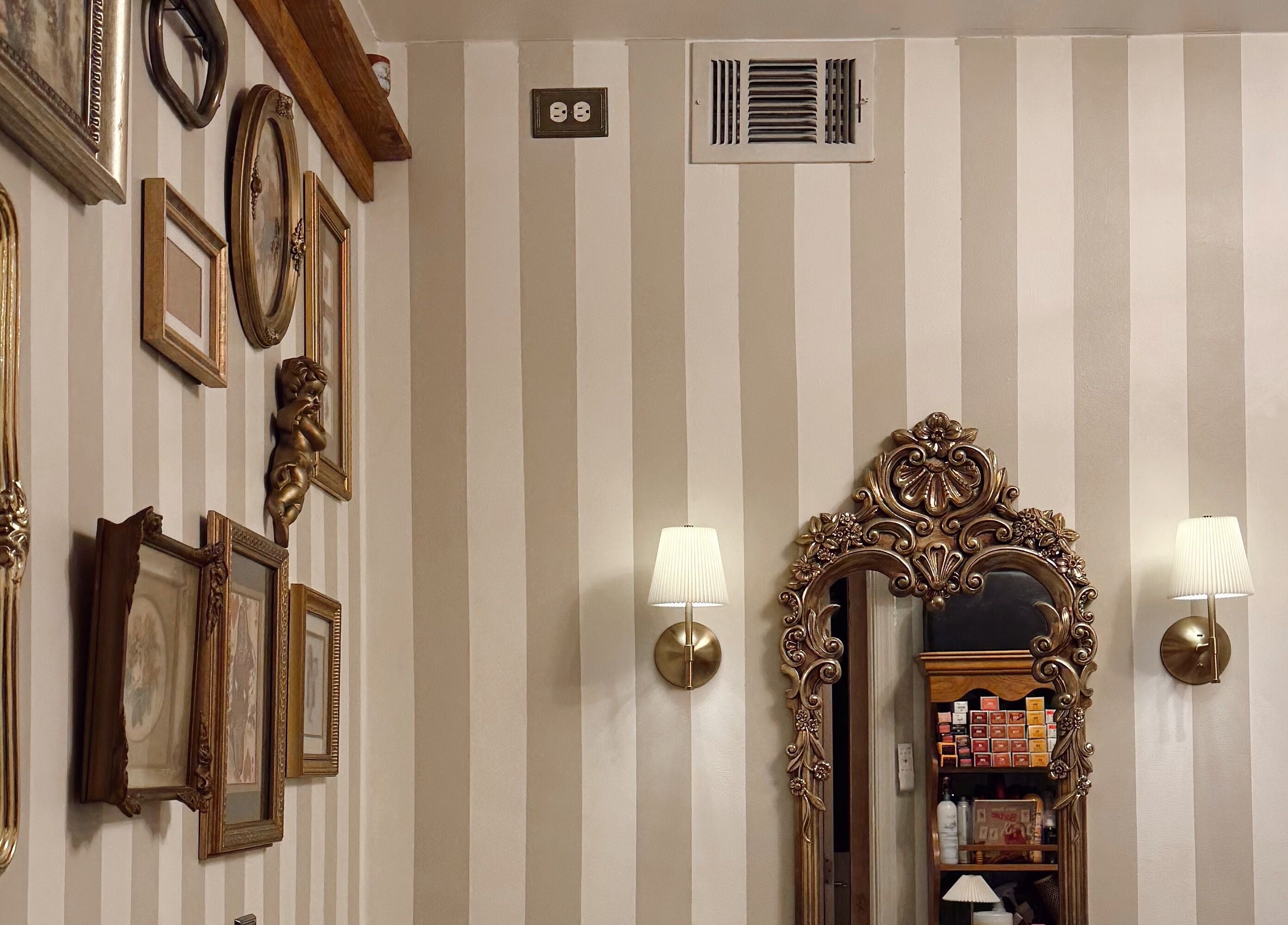 Ornate framed mirrors and decor on striped walls at Enhance Esthetics, Baltimore, Maryland, US.
