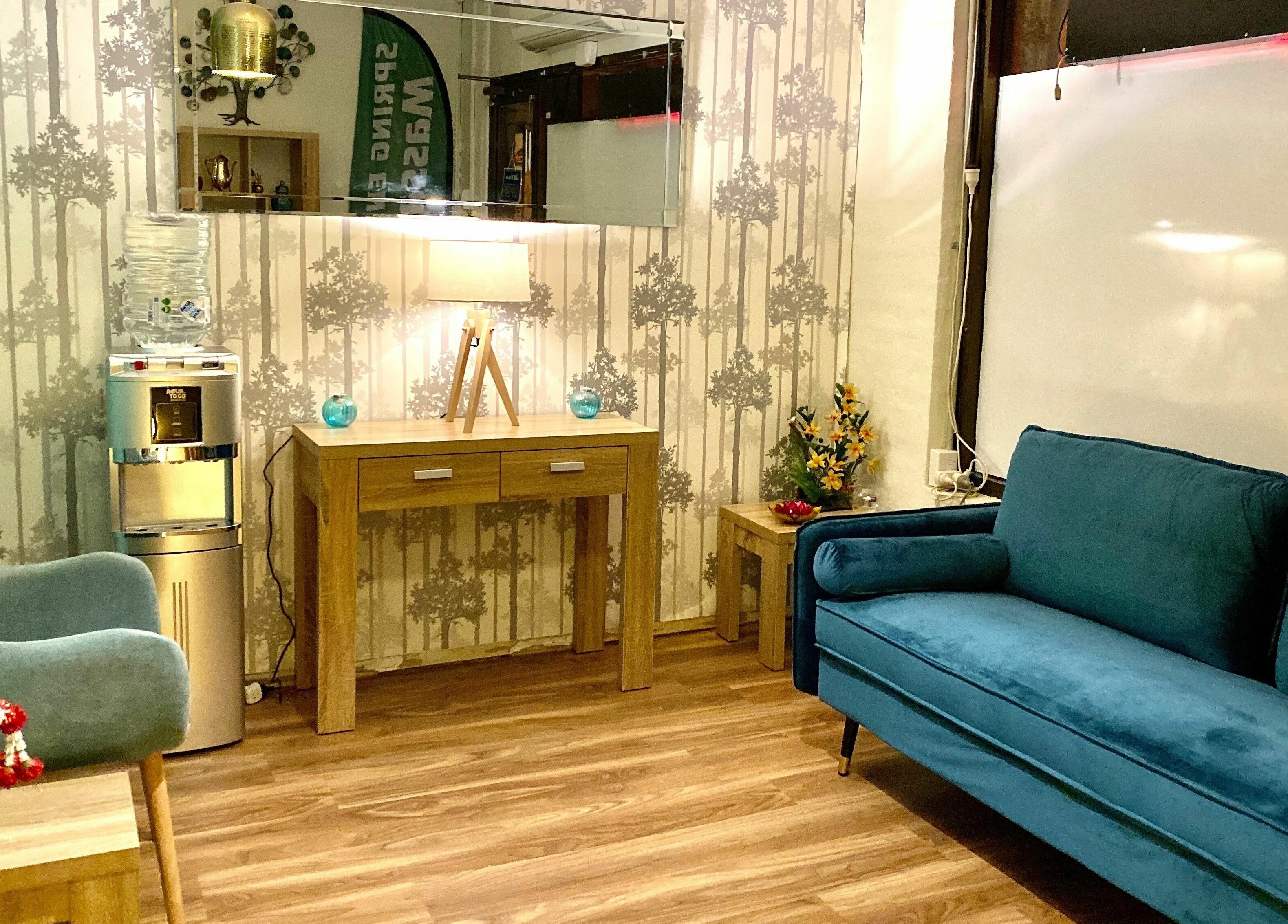 Relaxing lounge at Sawadee Hamilton in Hamilton, New South Wales, AU with a cozy blue sofa and wooden decor.