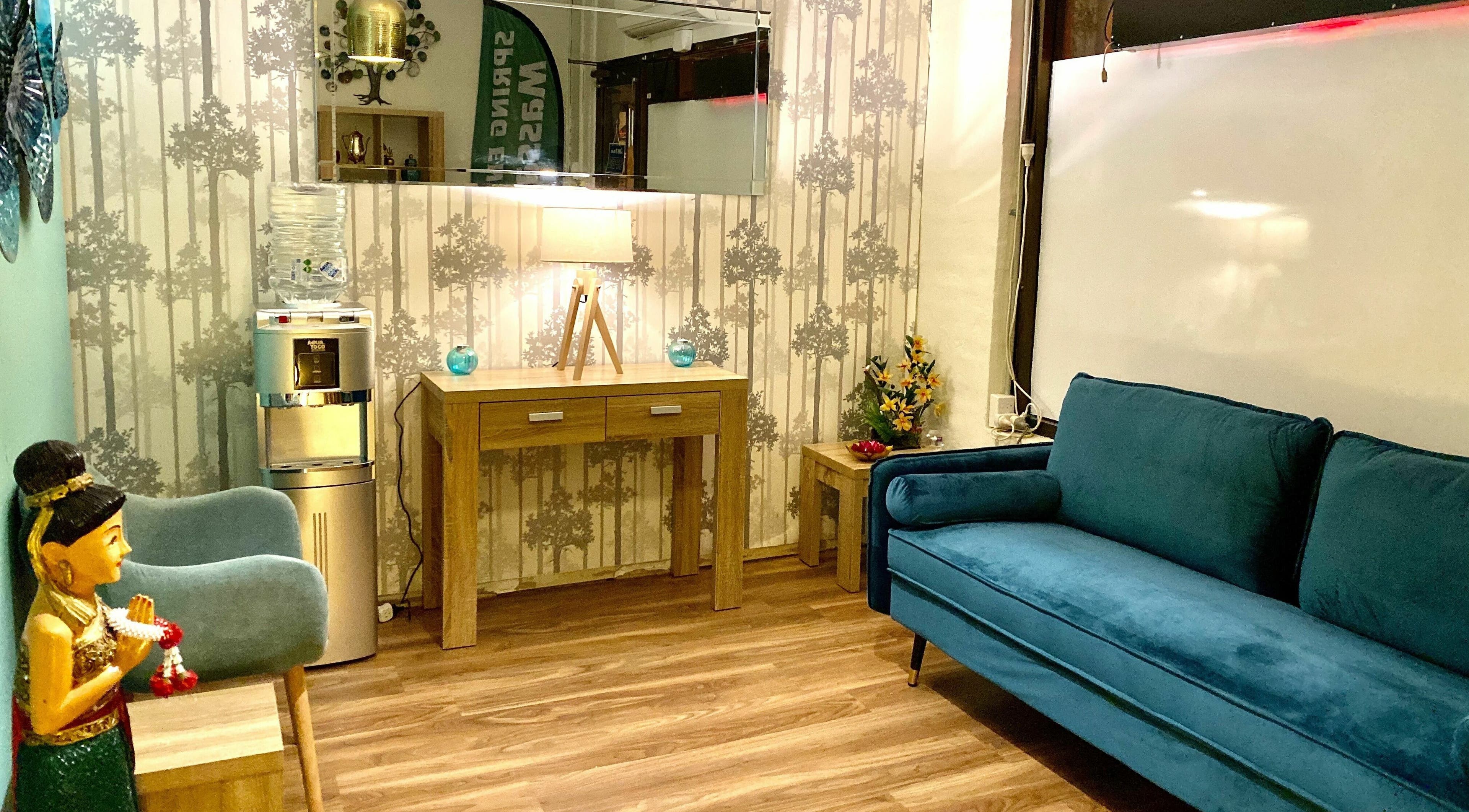 Relaxing lounge at Sawadee Hamilton in Hamilton, New South Wales, AU with a cozy blue sofa and wooden decor.