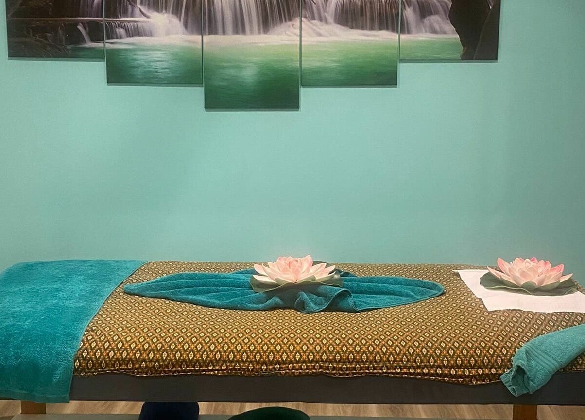 Massage table at Sawadee Cardiff in Cardiff, New South Wales, AU, with lotus decor and serene waterfall artwork.