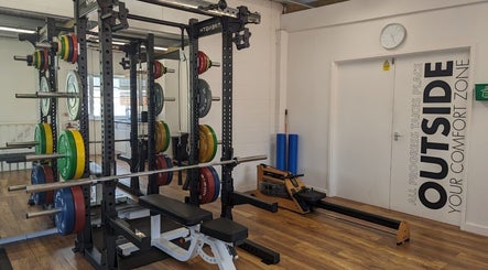 Weight racks and rowing machine at Exe Fitness, Exmouth, England, GB. Modern and motivational workout space.