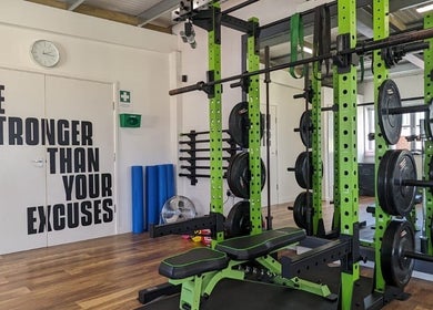 Weightlifting area at Exe Fitness in Exmouth, England, GB, featuring motivational wall art and modern equipment.