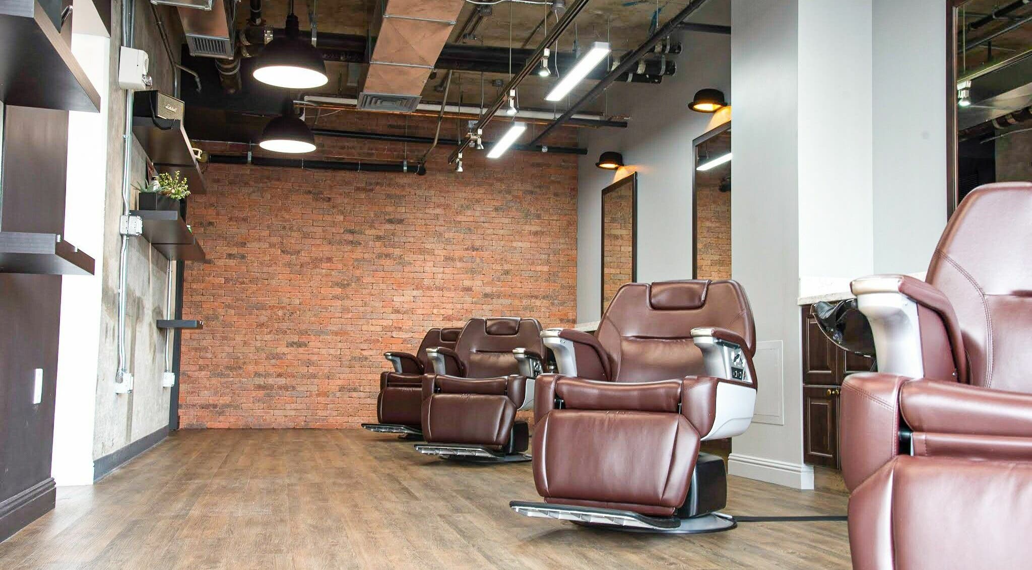 Modern barber chairs at Men's Grooming Salon SKY, Honolulu, Hawaii, US with exposed brick wall.