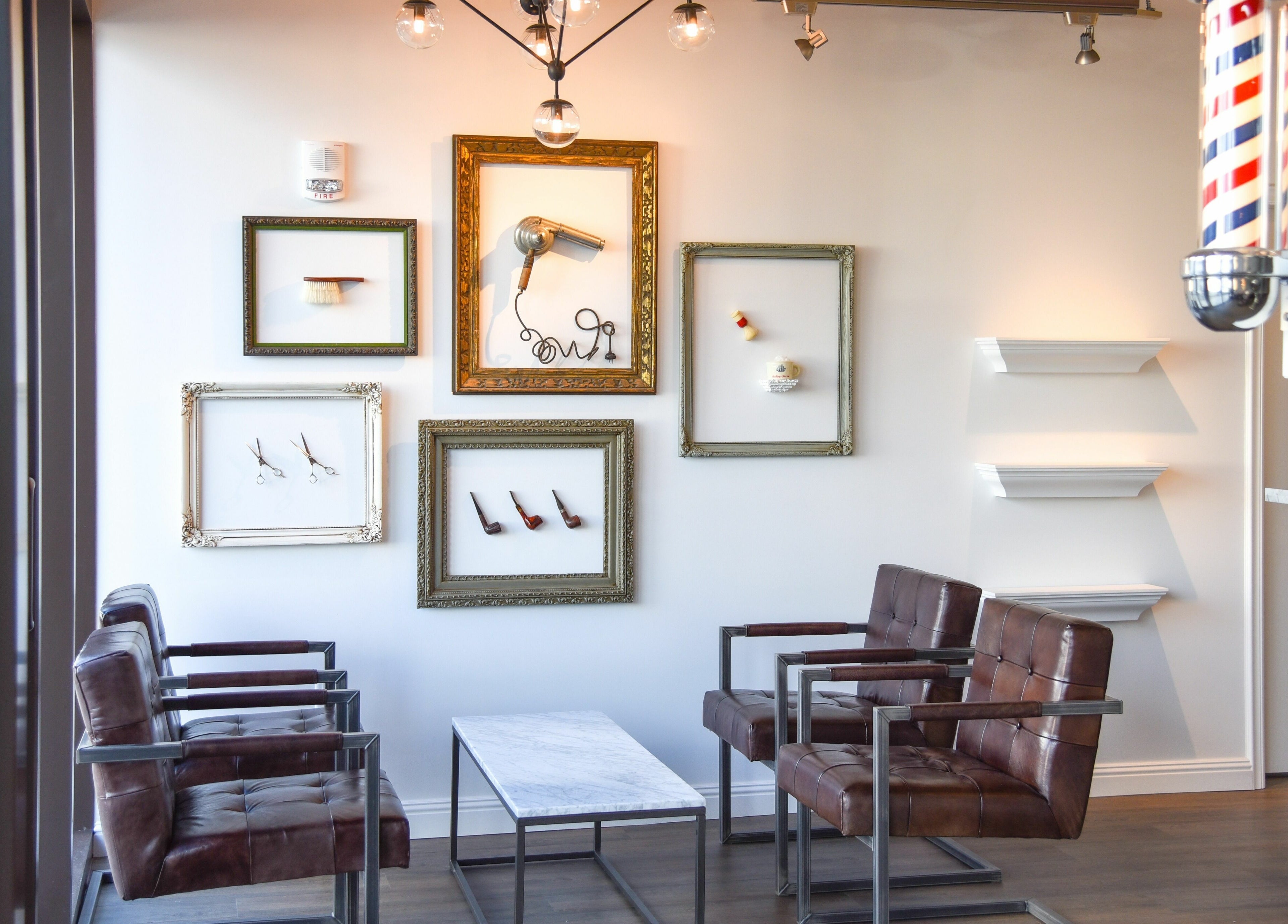 Chic lounge at Men's Grooming Salon SKY in Honolulu, Hawaii, US with leather chairs and framed decor.