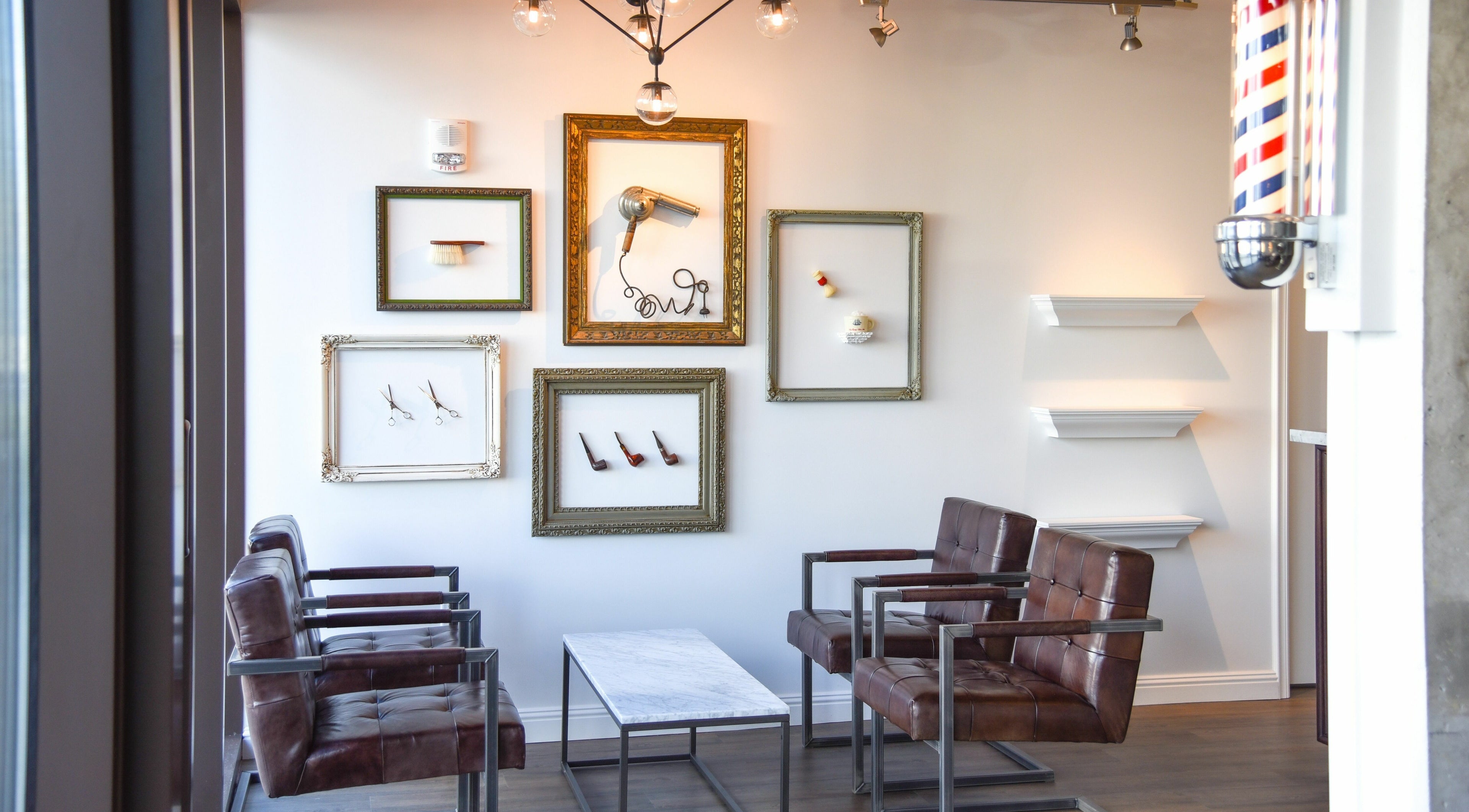 Chic lounge at Men's Grooming Salon SKY in Honolulu, Hawaii, US with leather chairs and framed decor.