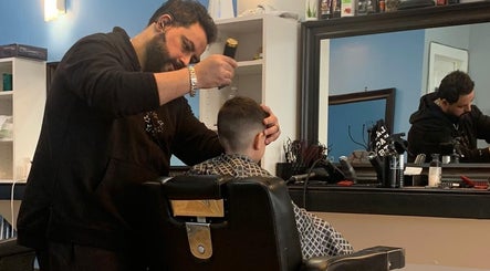 A barber masterfully trims a client's hair at Monaco Cuts in Hamilton, Ontario, CA, using expert techniques.