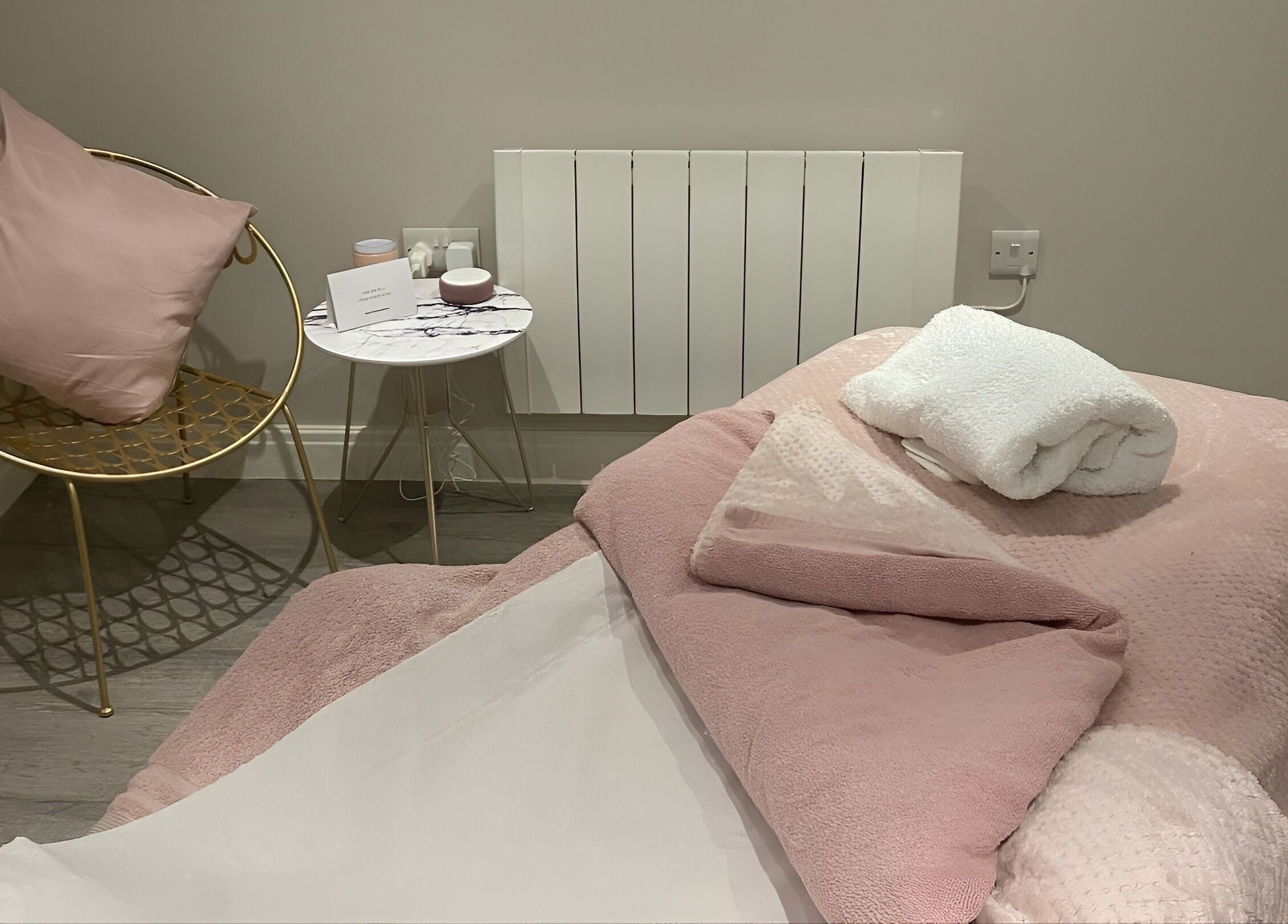 Elegant treatment room at No 5 Beauty, Wetherby, England, GB, featuring soft pink decor and plush seating.