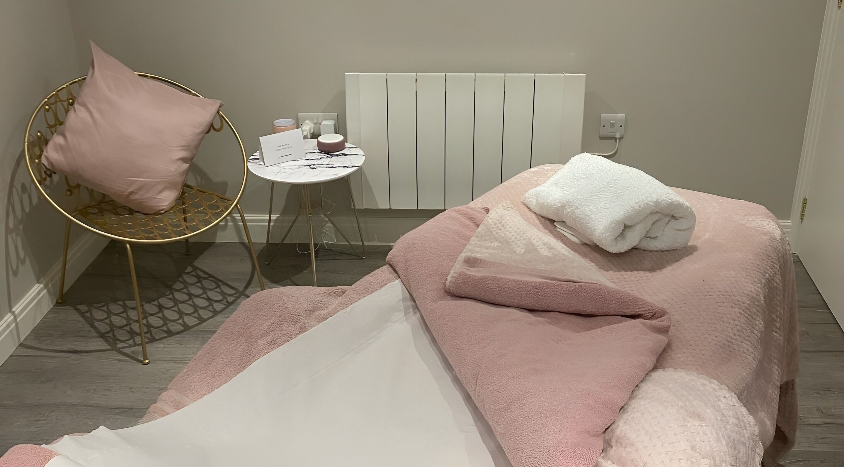 Elegant treatment room at No 5 Beauty, Wetherby, England, GB, featuring soft pink decor and plush seating.