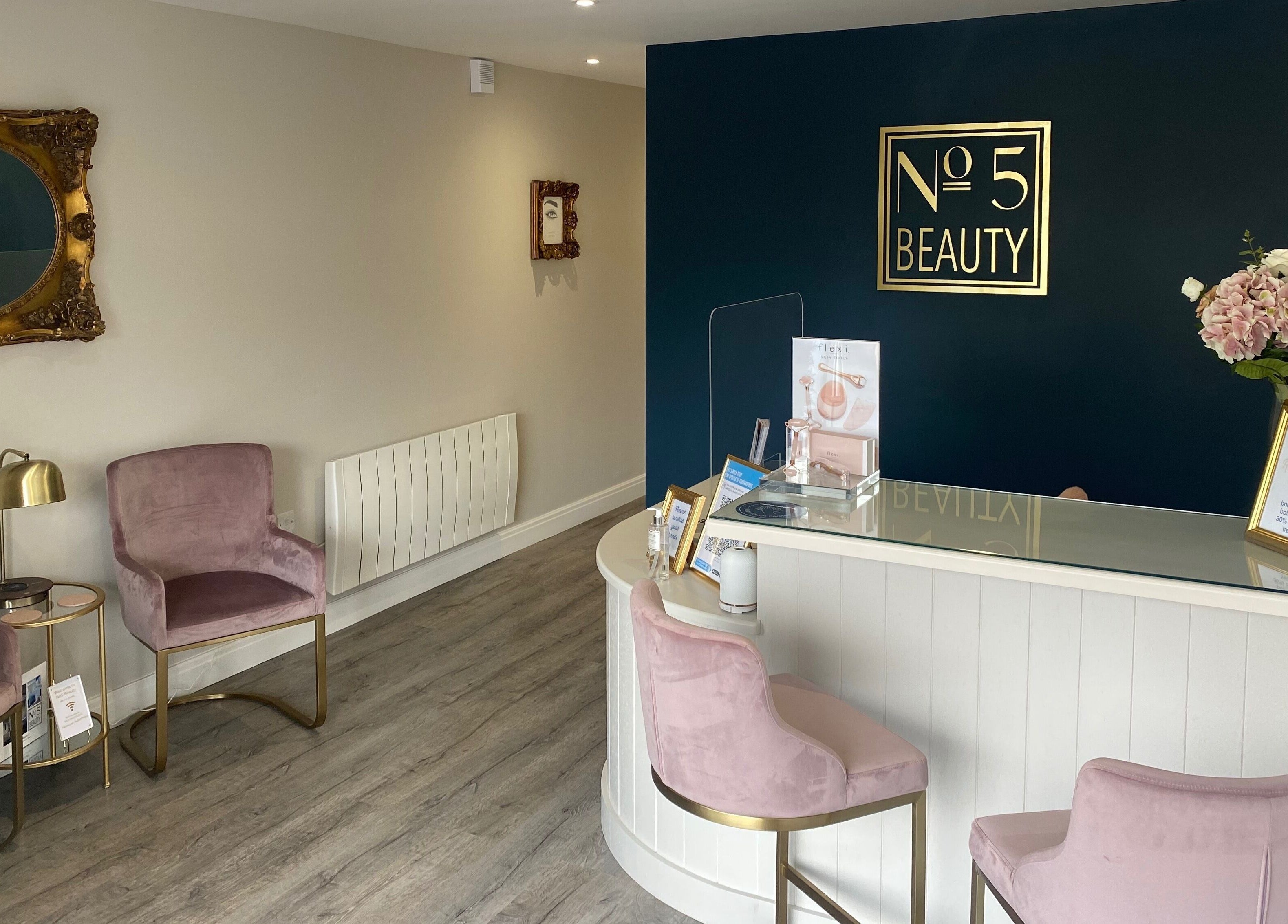 Elegant reception area at No 5 Beauty, Wetherby, England, GB with plush chairs and floral decor.