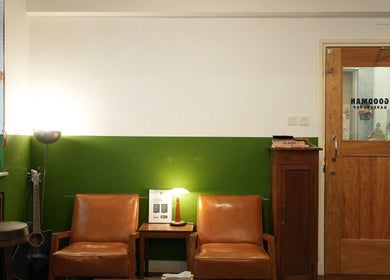 Inviting lounge area at Goodman Barber Shop (Causeway Bay), Hong Kong Island, HK. Brown chairs and green walls.