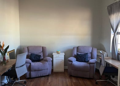 Cozy seating area at Genesis Beauty, Cape Town, Western Cape, ZA, featuring plush chairs and warm decor.
