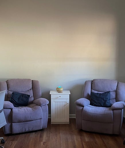 Cozy seating area at Genesis Beauty, Cape Town, Western Cape, ZA, featuring plush chairs and warm decor.