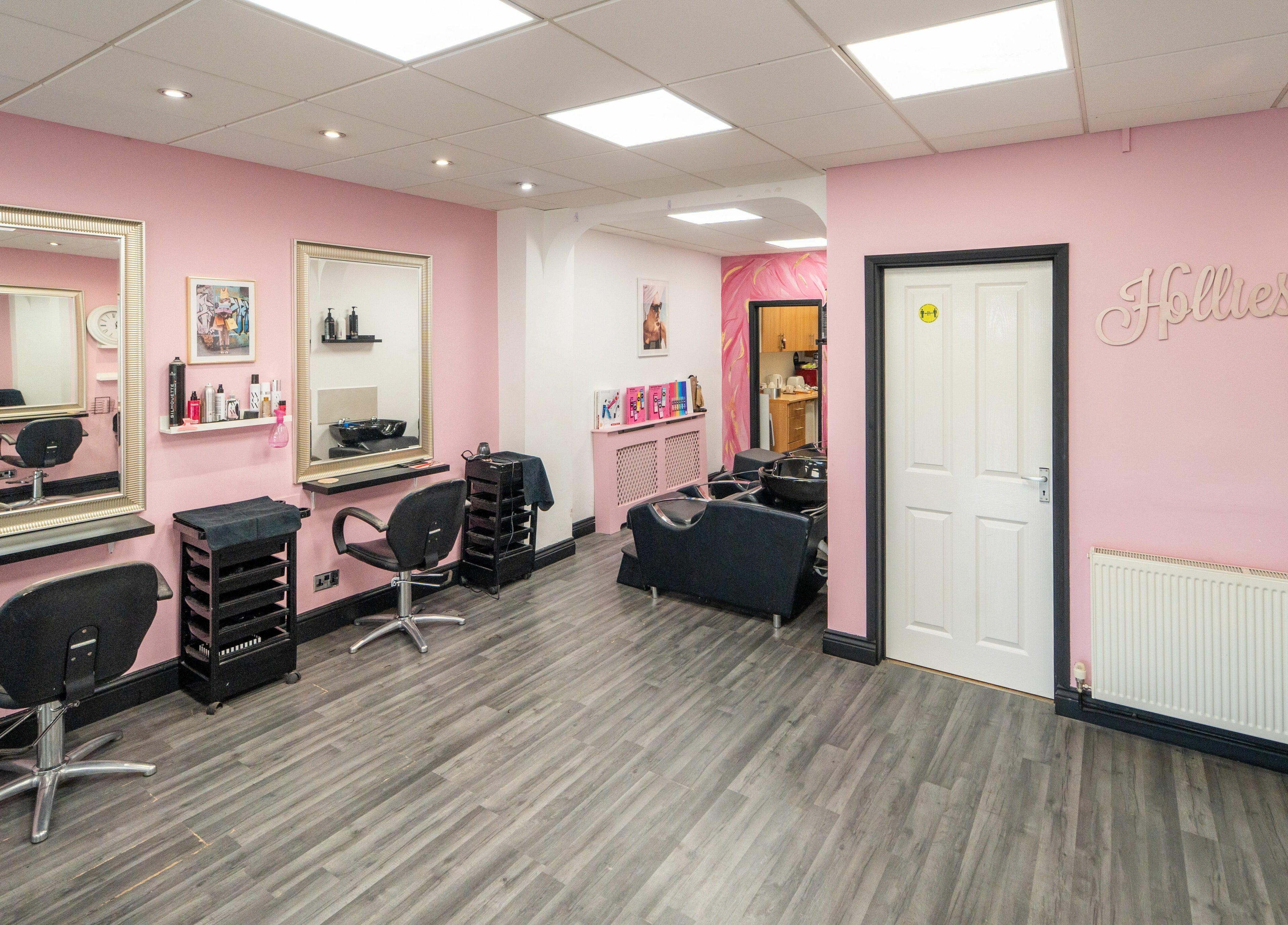 Modern interior of Hollieslocks Salon in Hornchurch, England, GB with stylish chairs and mirrors.