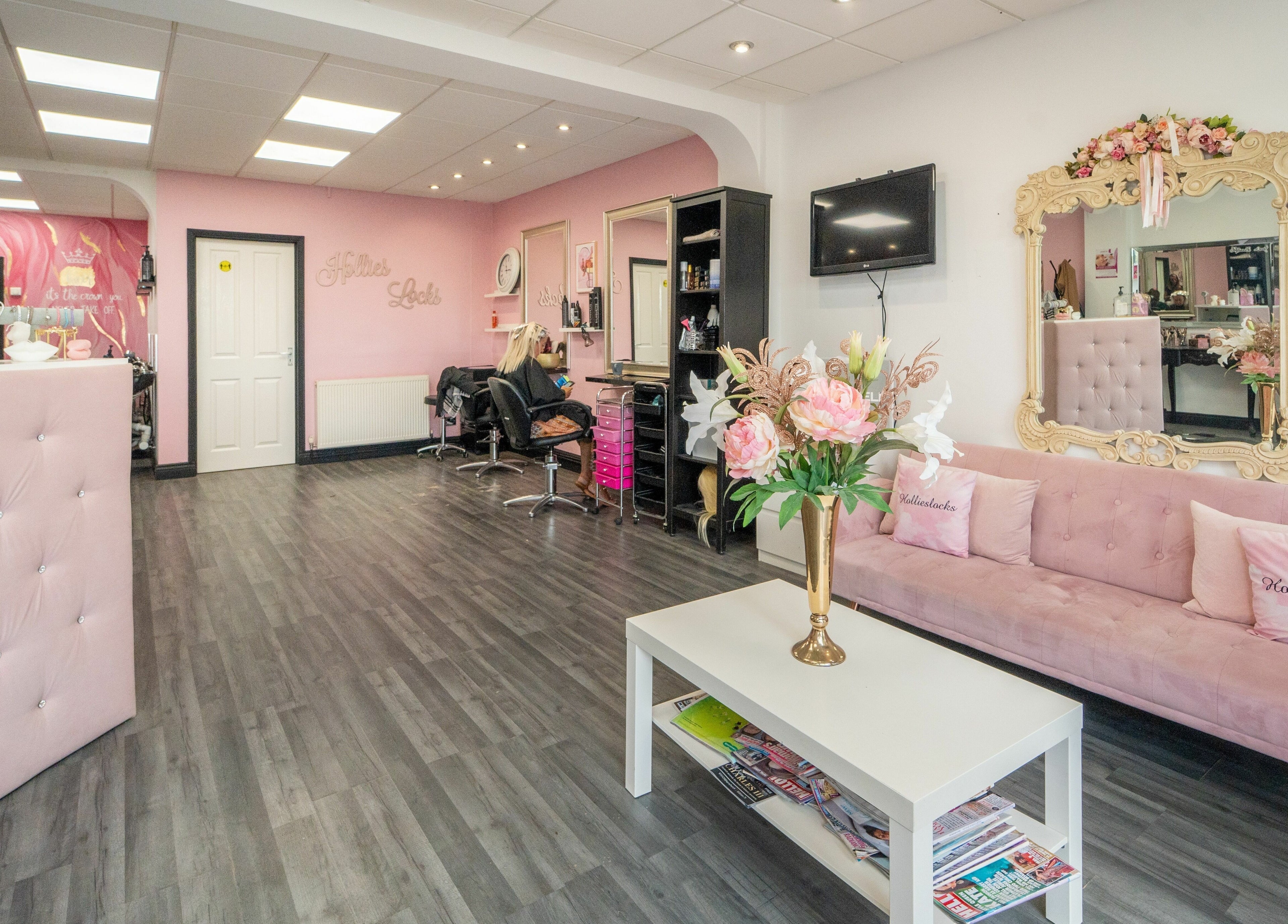 Interior of Hollieslocks Salon in Hornchurch, England, GB, with a stylish pink and white decor.