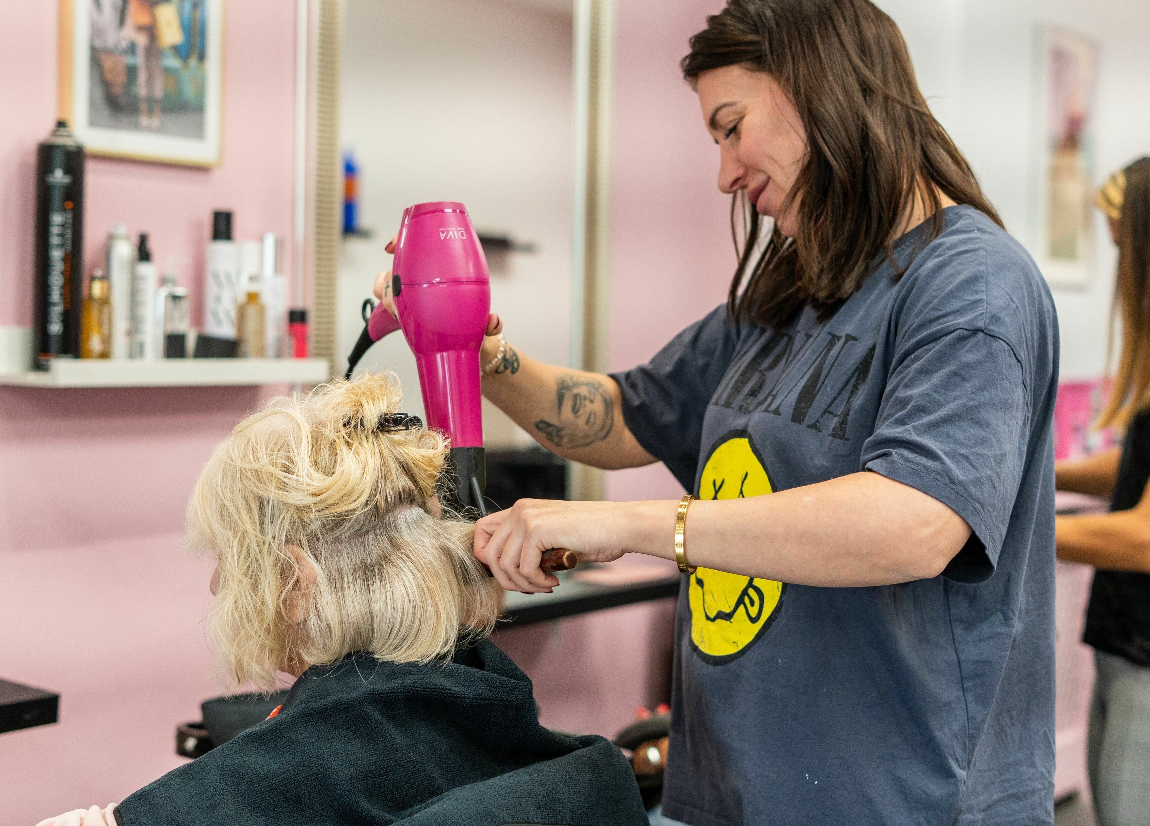 Stylist blow-drying hair at Hollieslocks Salon, Hornchurch, England, GB, creating a chic look.