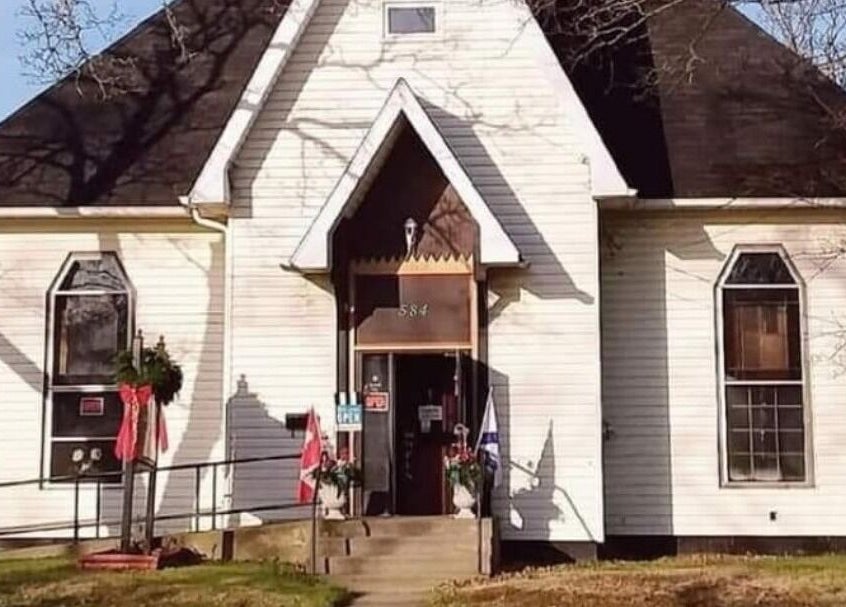 Steampunk'd Salon and Gallery, Yarmouth, Nova Scotia, CA, quaint wooden facade with Canadian flags.