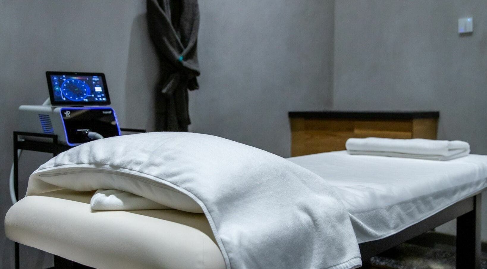 Relaxing treatment room at RESYNC, Dubai, AE with a comfortable massage bed and modern equipment.