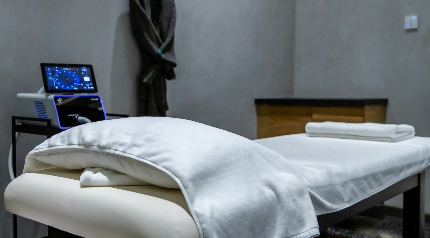 Relaxing treatment room at RESYNC, Dubai, AE with a comfortable massage bed and modern equipment.