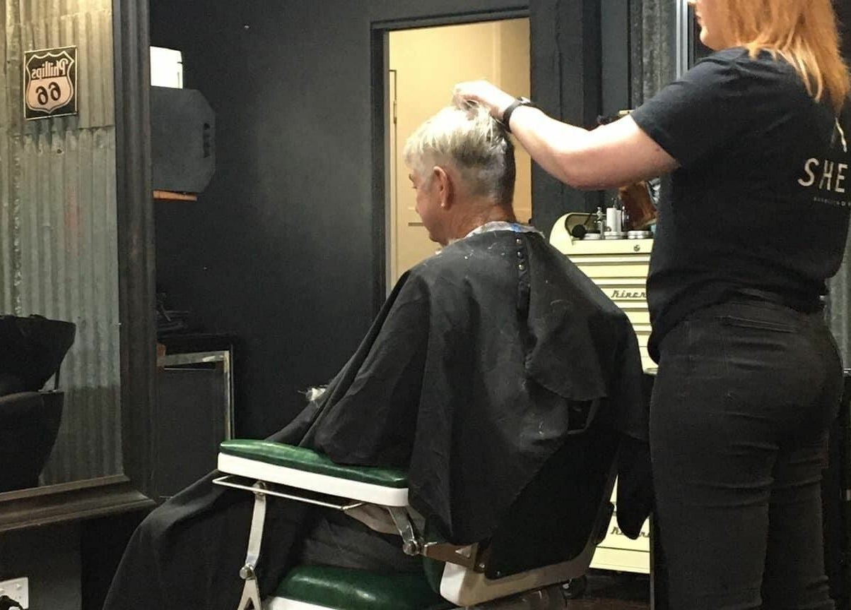 A stylist cuts hair at SHED Barbershop in Gladstone Central, Queensland, AU, reflecting a chic and modern setting.