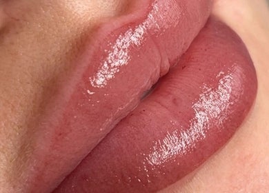 Glossy pink lips showcasing lip treatment at Emily Marietta Barker, Glasgow, Scotland, GB.