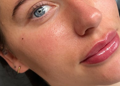 Close-up of a woman's radiant skin and glossy lips at Emily Marietta Barker, Glasgow, Scotland, GB.