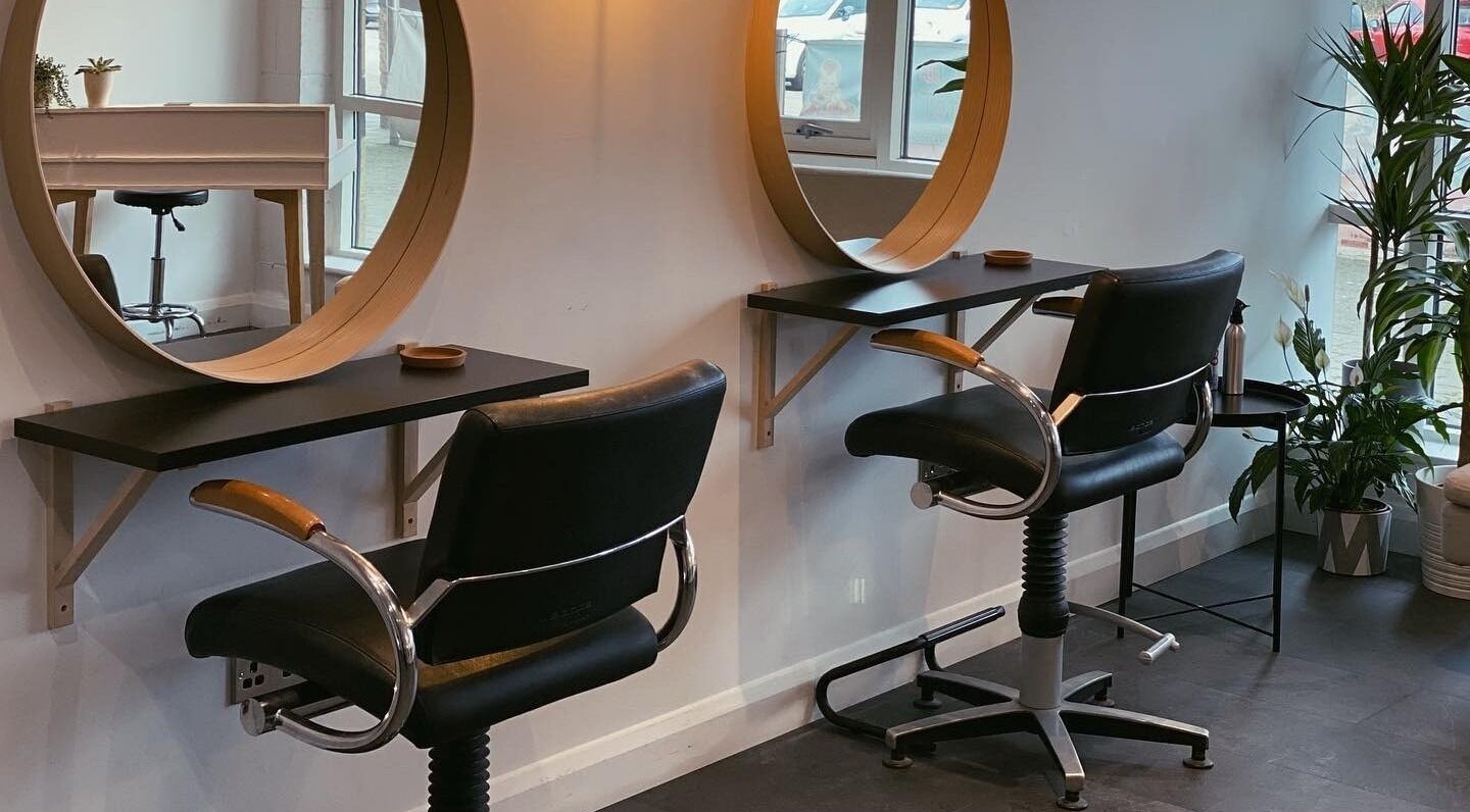Modern styling stations at Fika Hair - Caton Road in Lancaster, England, GB with black chairs and wooden mirrors.