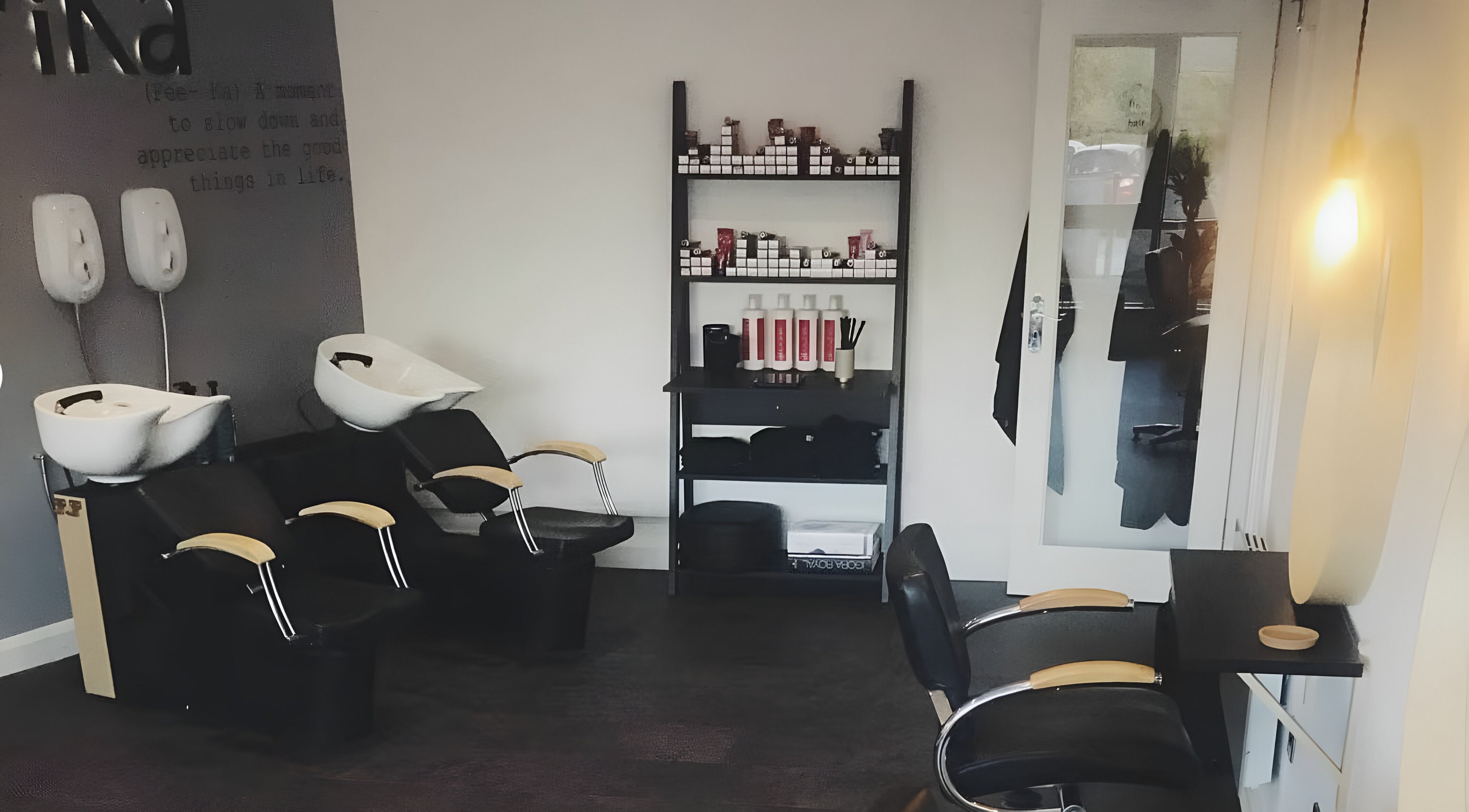 Modern wash station at Fika Hair - Caton Road, Lancaster, England, GB with stylish chairs and product display.