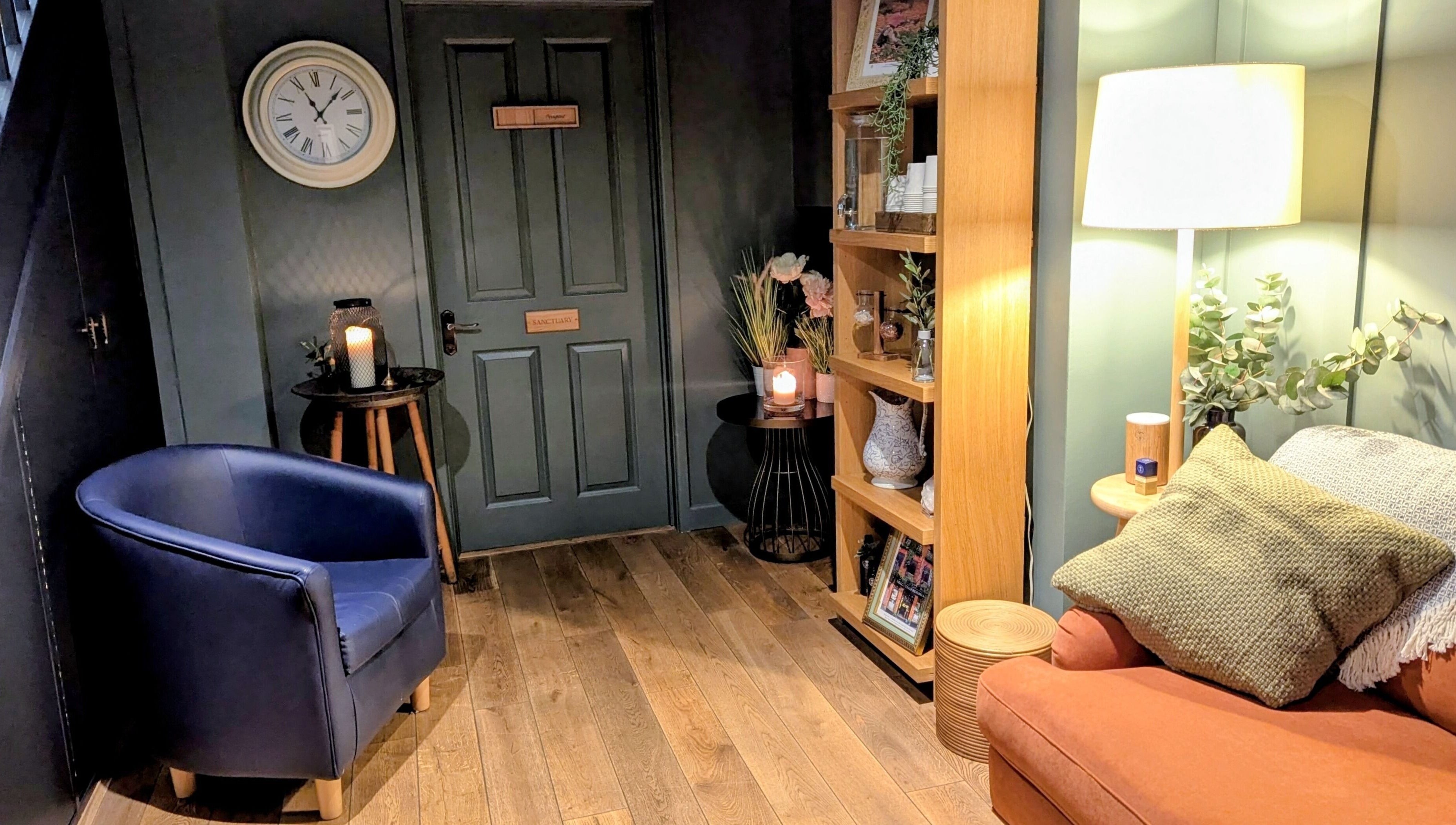 Inviting corner at Sanctuary & Sage, Cheltenham, England, GB. Warm lighting, plush seating, and decor.