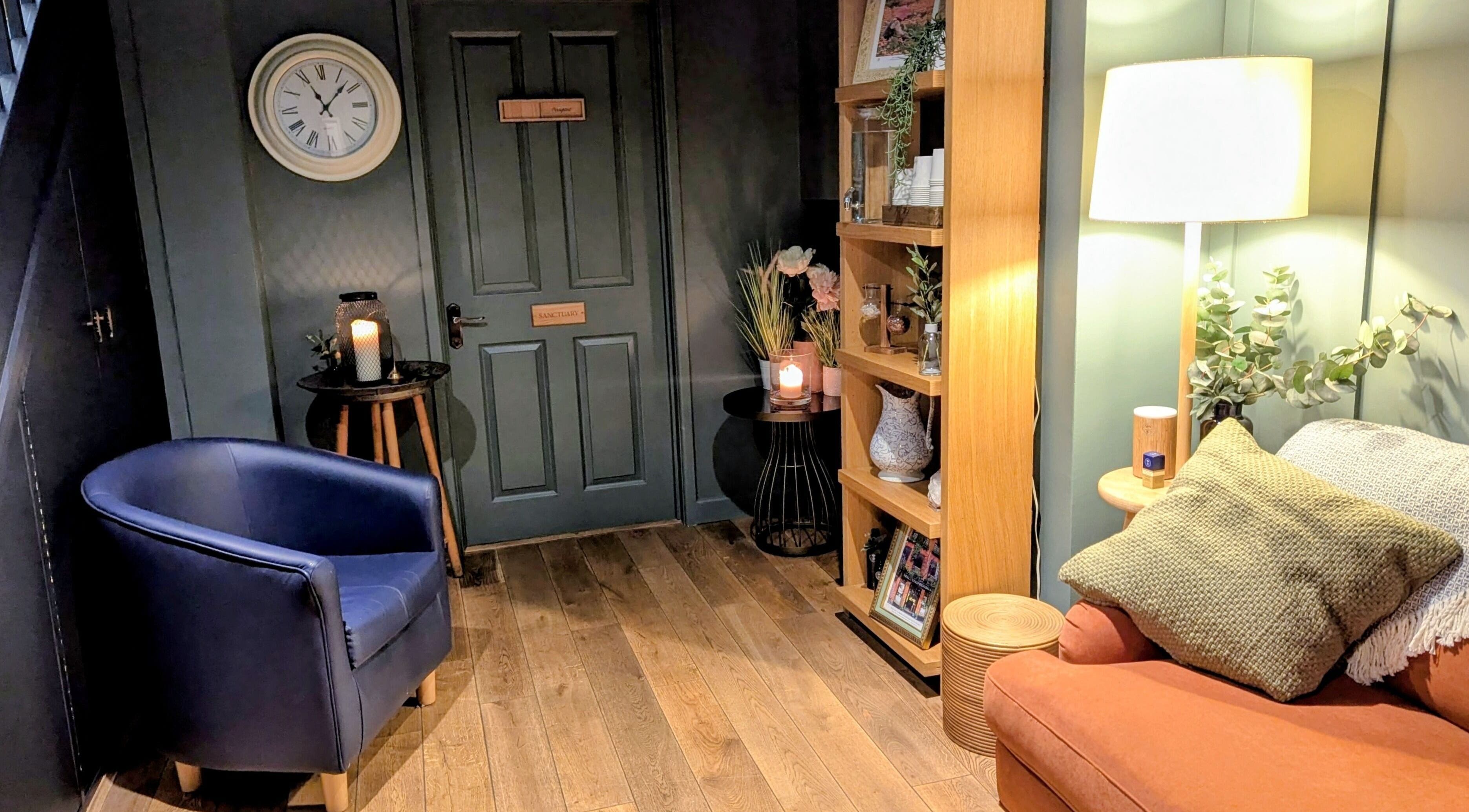 Inviting corner at Sanctuary & Sage, Cheltenham, England, GB. Warm lighting, plush seating, and decor.