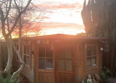 Peaceful garden retreat at The Massage Place, Glastonbury, England, GB, with a sunset backdrop and calming atmosphere.