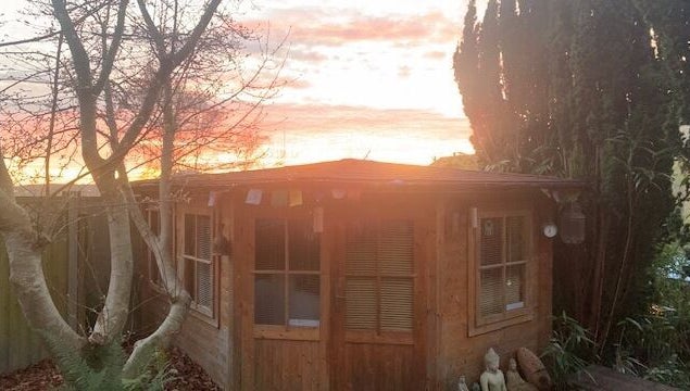 Peaceful sunset view of The Massage Place in Glastonbury, England, GB, with tranquil garden setting.