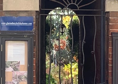 Entrance to The Massage Place, Glastonbury, England with inviting garden view.