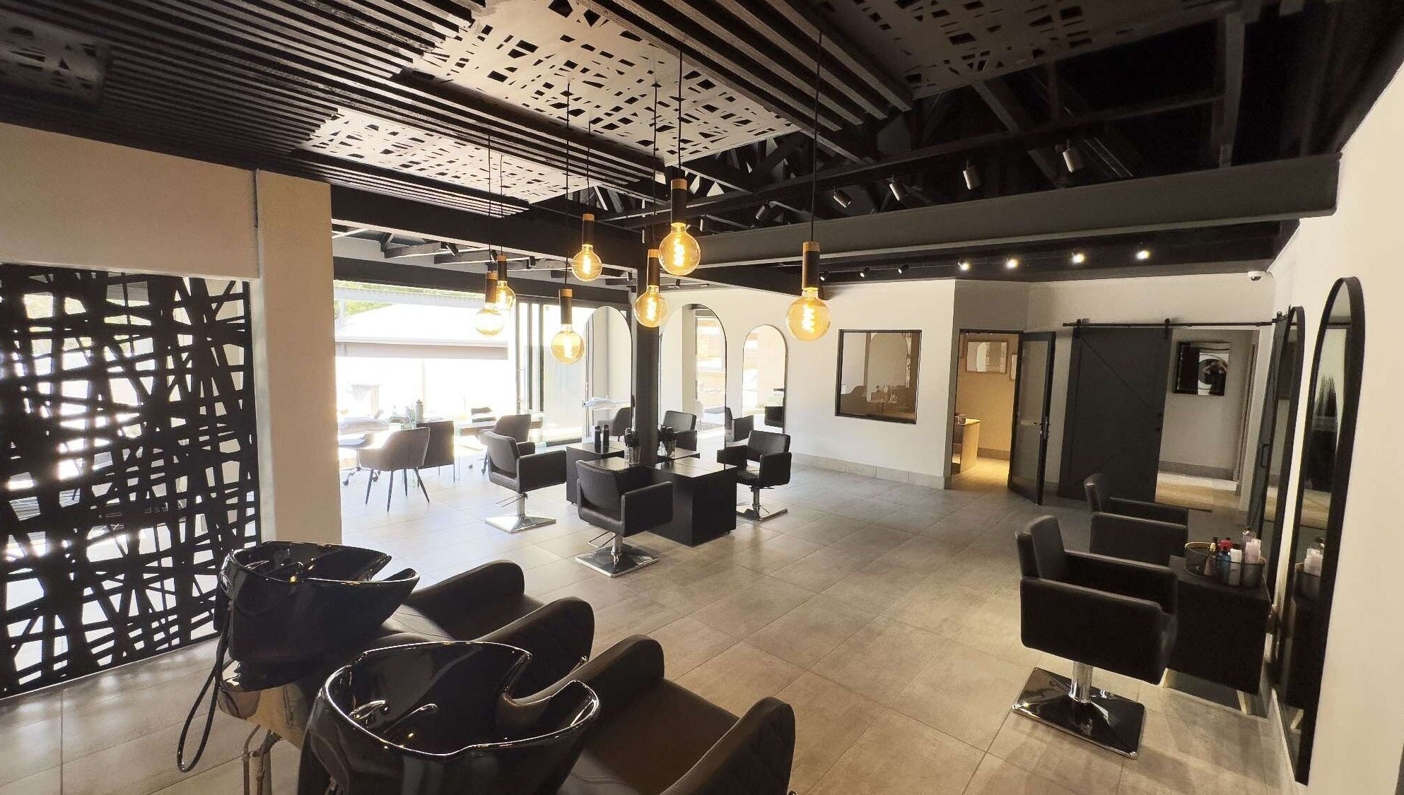 Modern interior of The Glow salon in Benoni, Gauteng, ZA with stylish chairs and ambient lighting.
