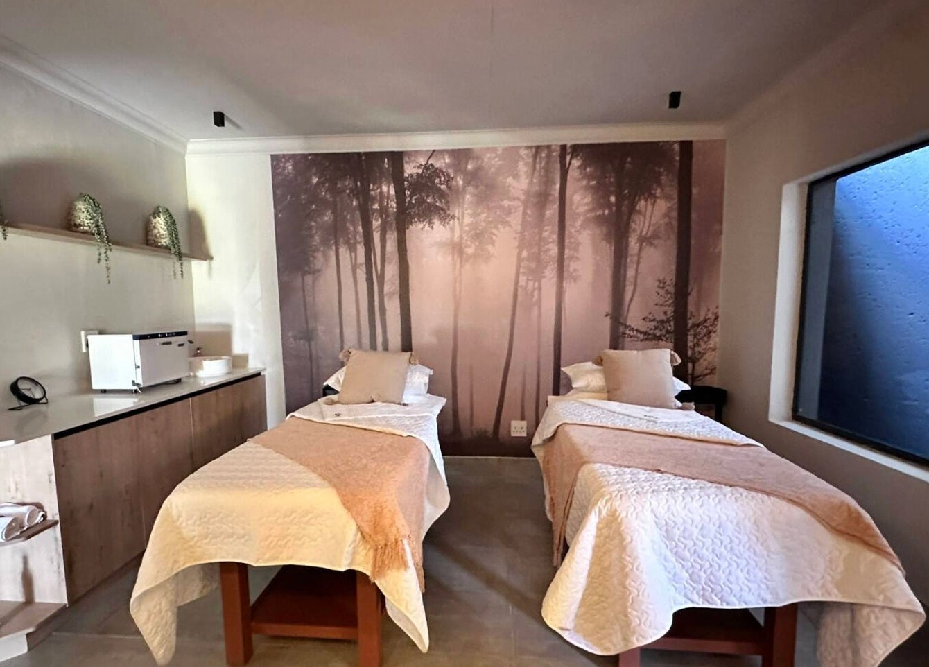 Relaxing treatment room at The Glow, Benoni, Gauteng, ZA, featuring two massage beds with nature-themed decor.