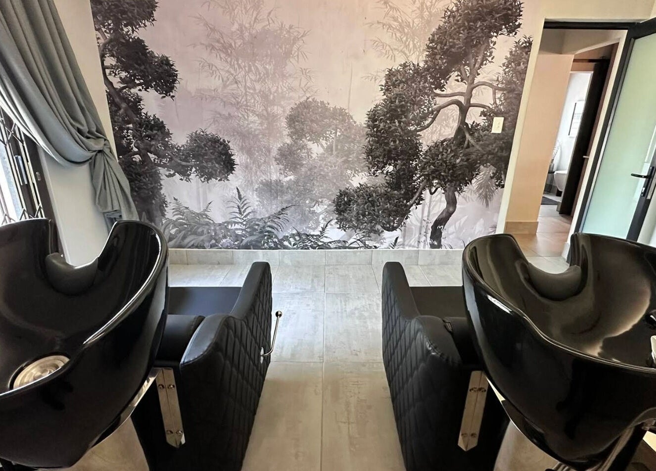 Stylish wash stations at The Glow, Benoni, Gauteng, ZA, featuring sleek black basins and an elegant backdrop.