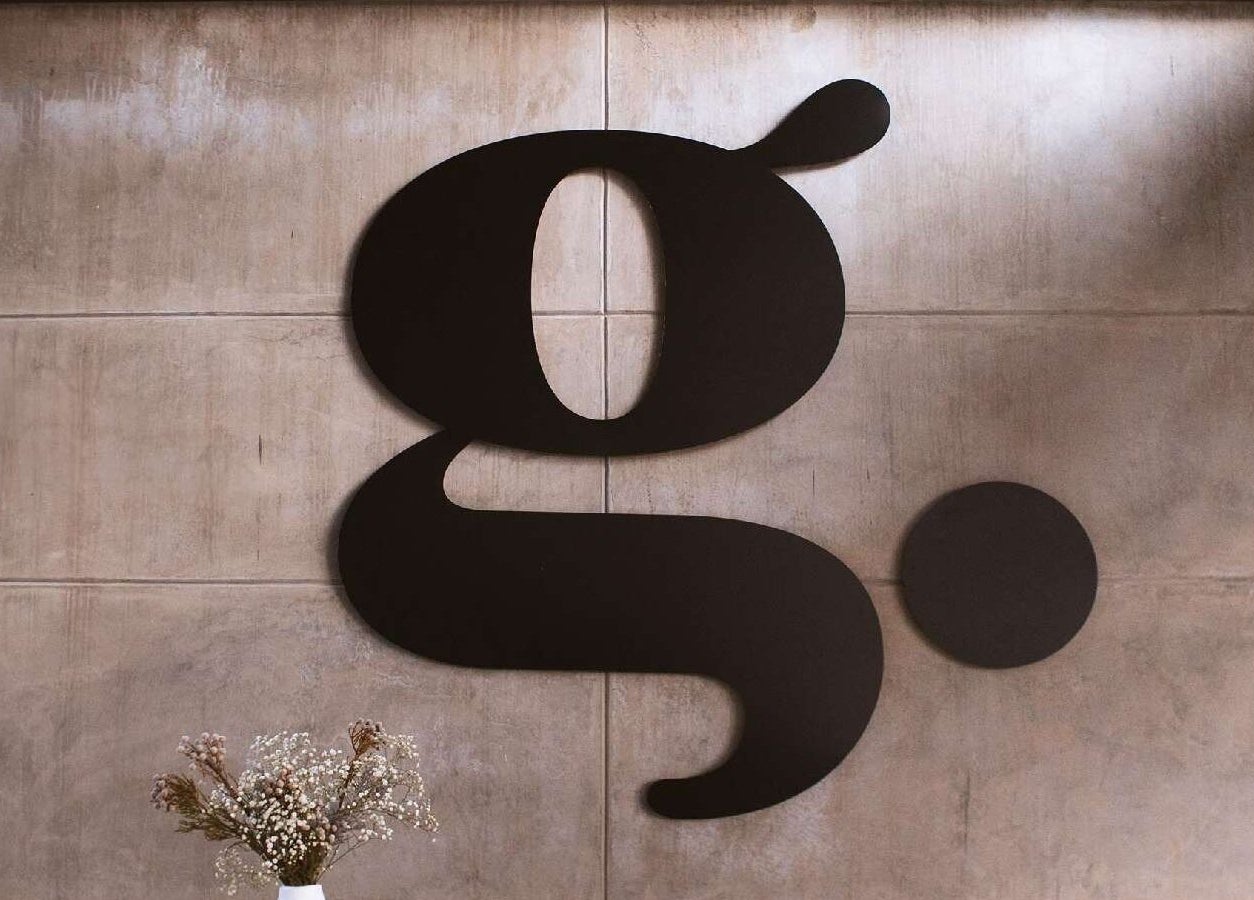 The Glow's elegant logo on concrete wall at Benoni, Gauteng, ZA venue.