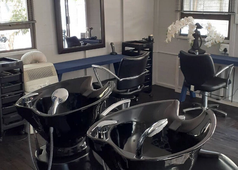 Modern salon interior at Studio M in Randburg, Gauteng, ZA with sleek hair-washing stations.