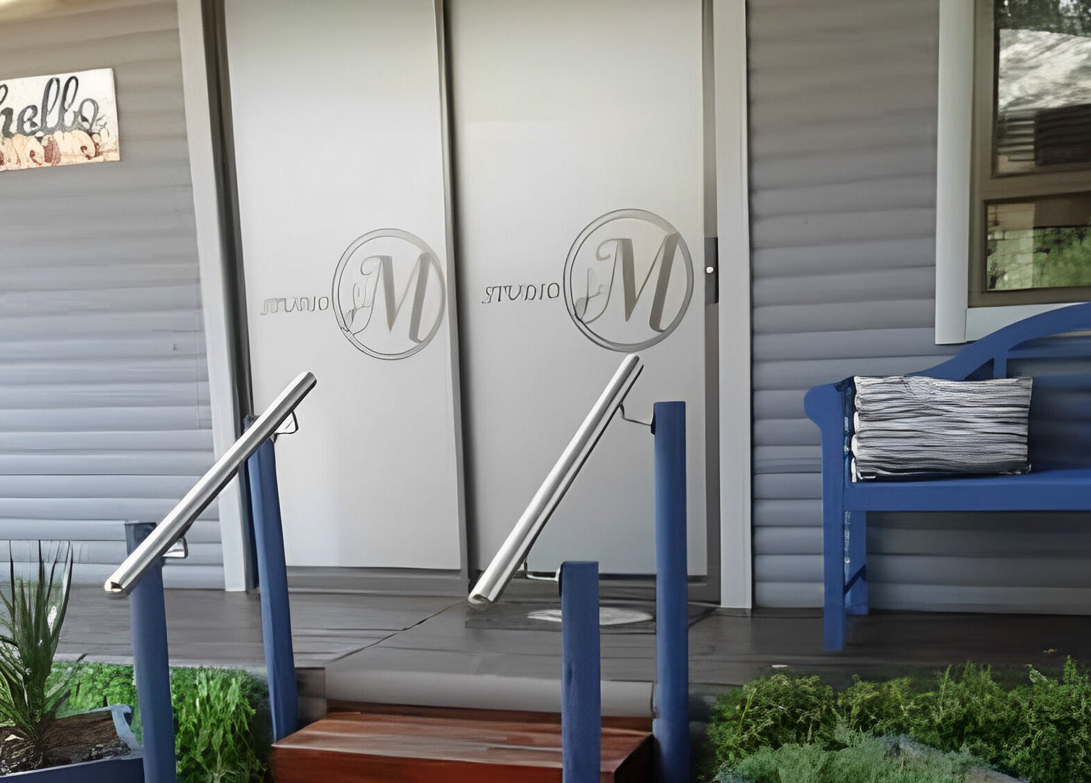 Inviting entrance of Studio M, Randburg, Gauteng, ZA, featuring sleek doors and a cozy blue bench.