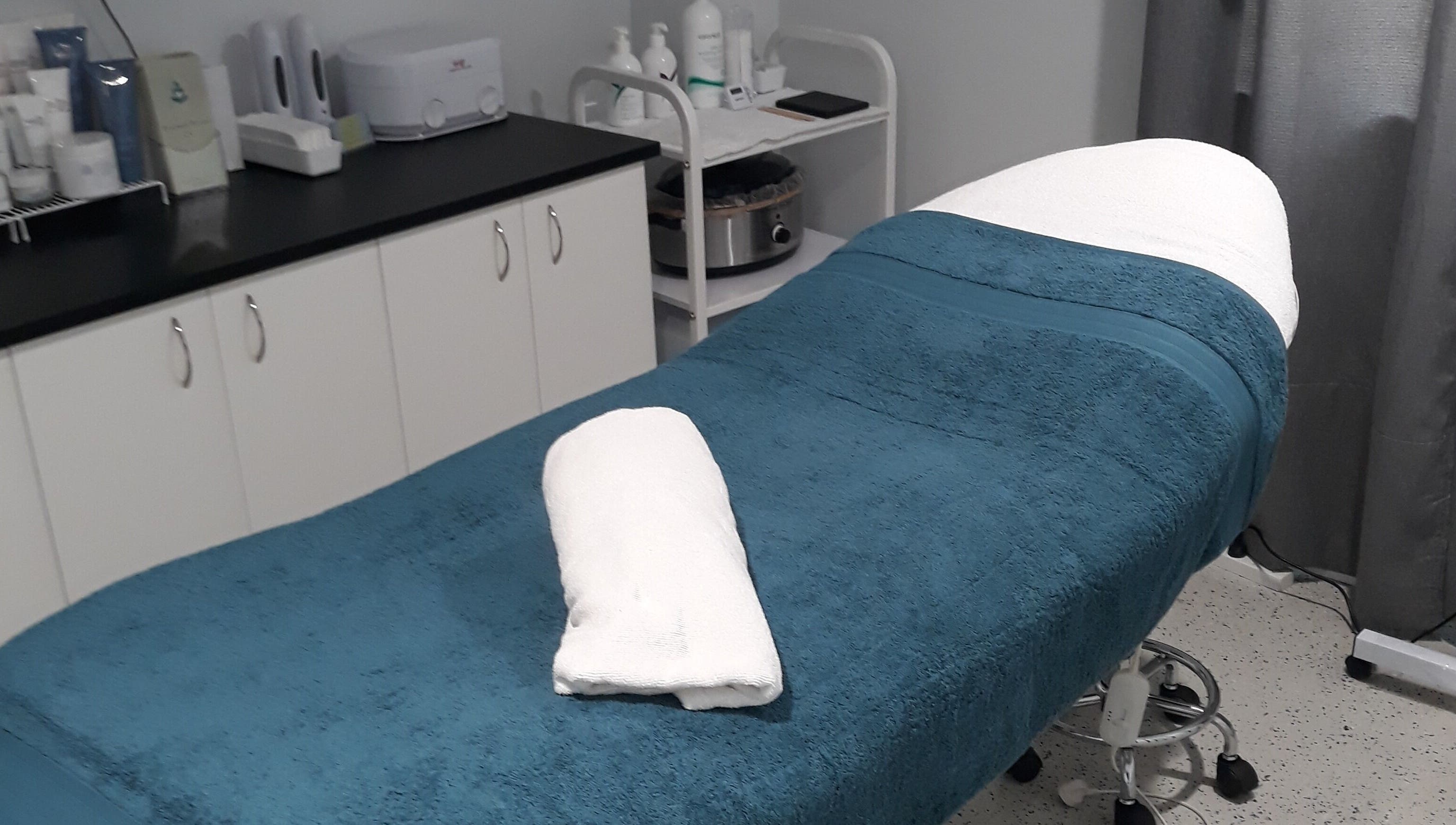 Serene treatment room at Essential Beauty 2 U, Victory Heights, Queensland, AU with a cozy massage bed.
