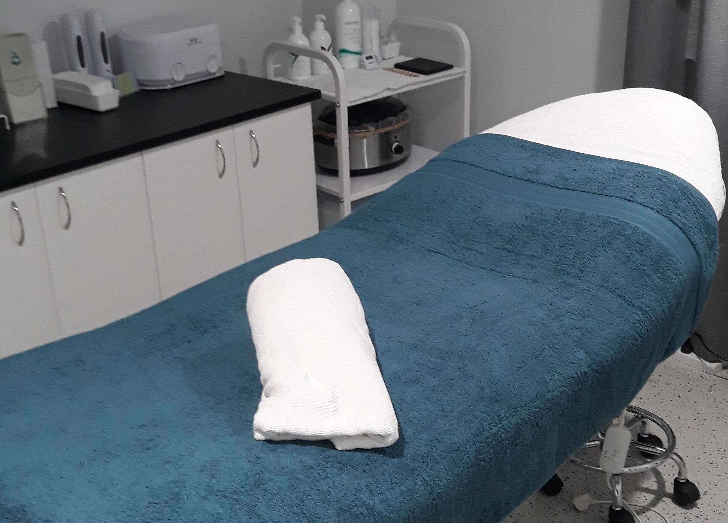 Serene treatment room at Essential Beauty 2 U, Victory Heights, Queensland, AU with a cozy massage bed.