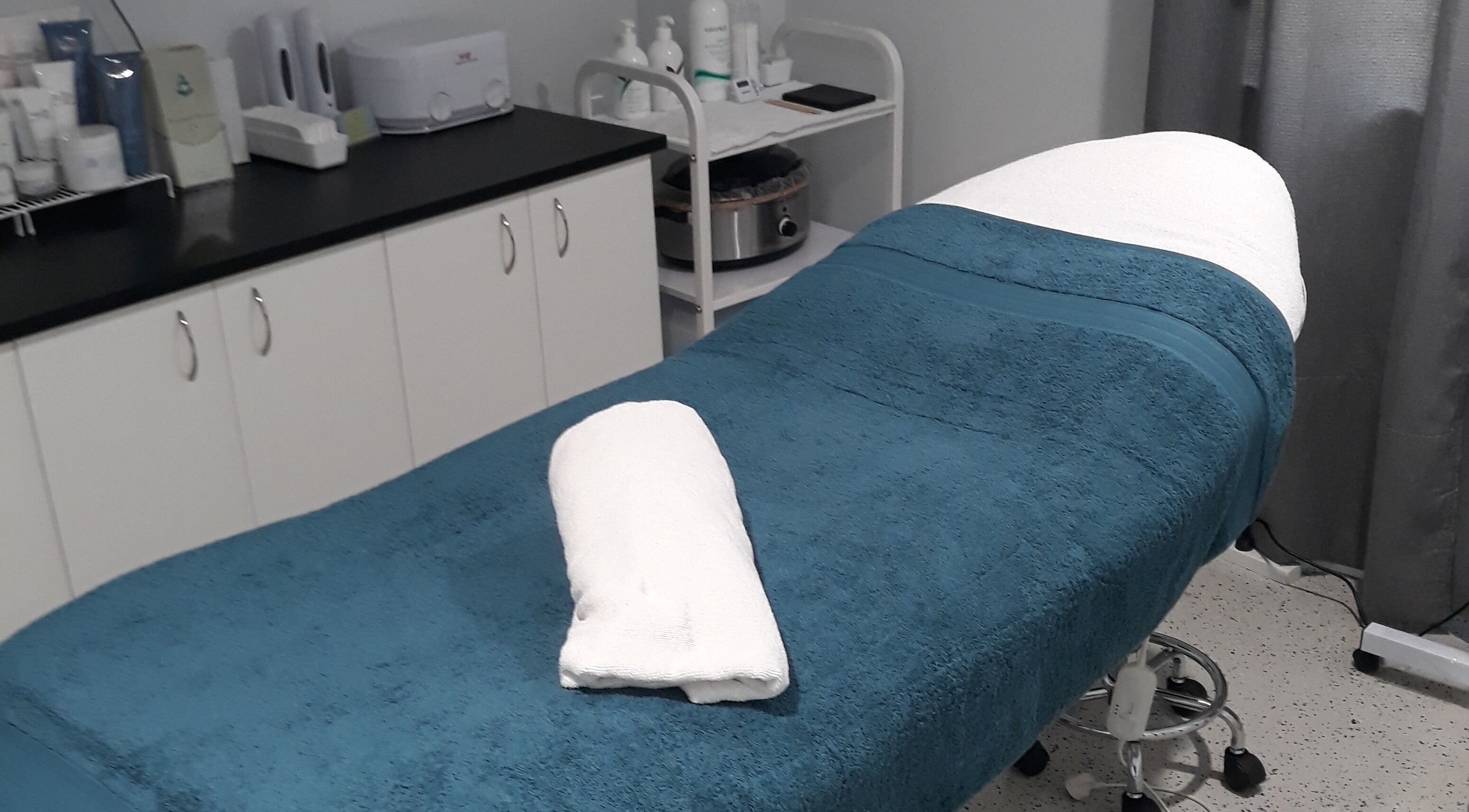 Serene treatment room at Essential Beauty 2 U, Victory Heights, Queensland, AU with a cozy massage bed.