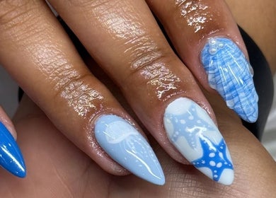 Elegant blue nail art with oceanic theme by Davie Nails in Davie, Florida, US. Intricate designs on fingers.