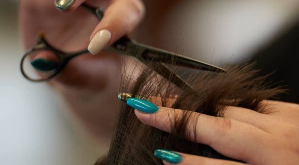 Expert hair trim at Dom Republic, Johannesburg, Gauteng, ZA. Precision scissors and styled nails in focus.